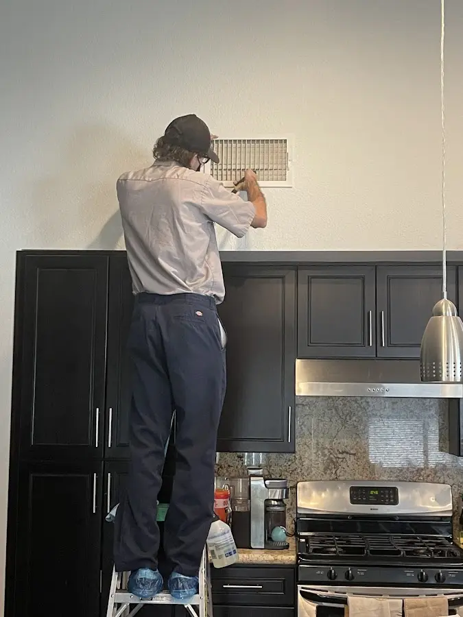 Technician inspecting an air vent during HVAC service in Mount Vernon